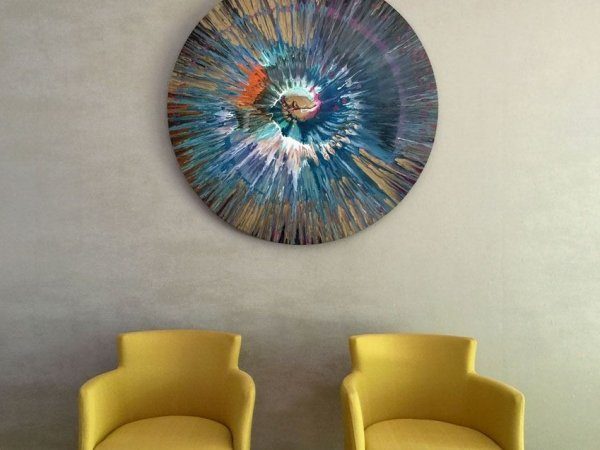 Blue spin art and two mustard yellow chairs