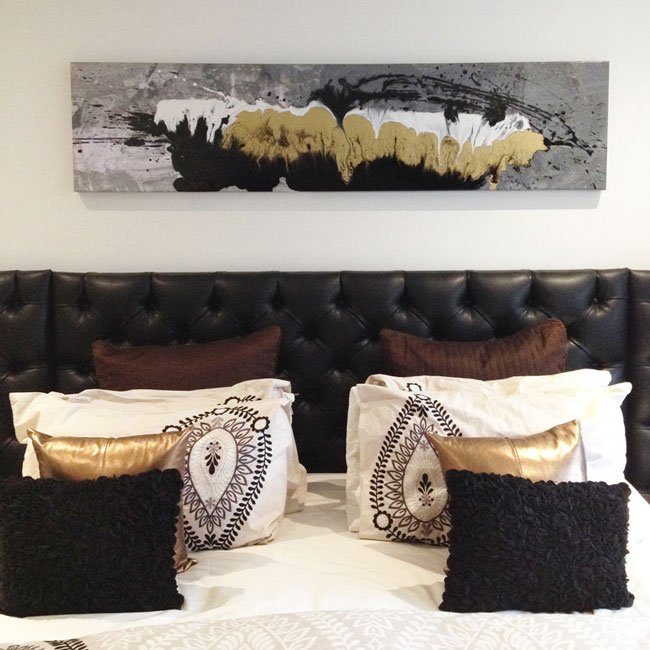 black quilt and gold cushions on a bed