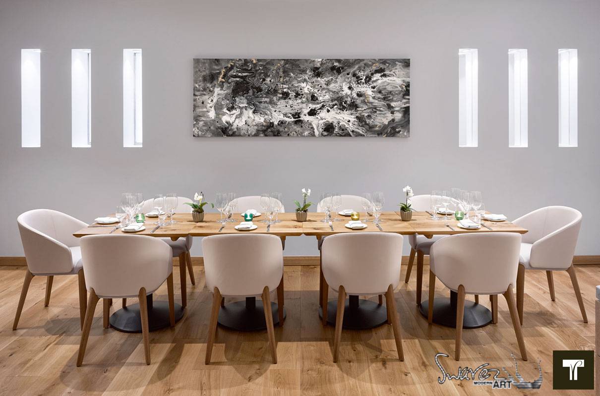 Meteopric Rise painting hanging above a long dining table and chairs