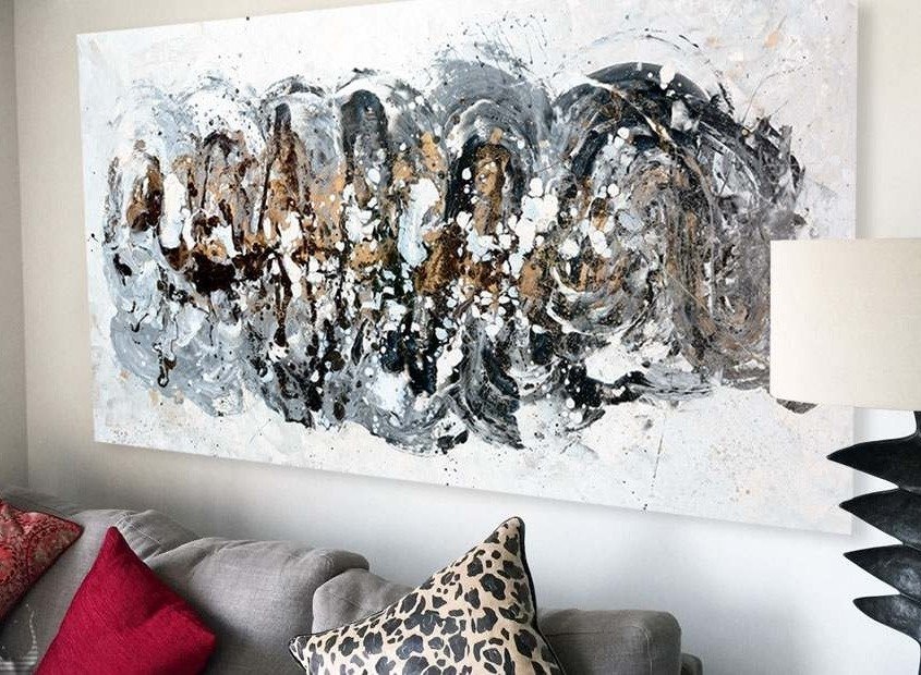 A medium sized black and gold abstract art painting above a sofa