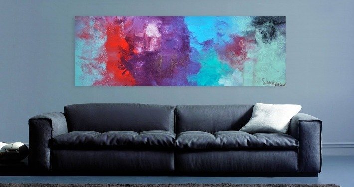 Grey walls and a sofa with abstract art hanging above it