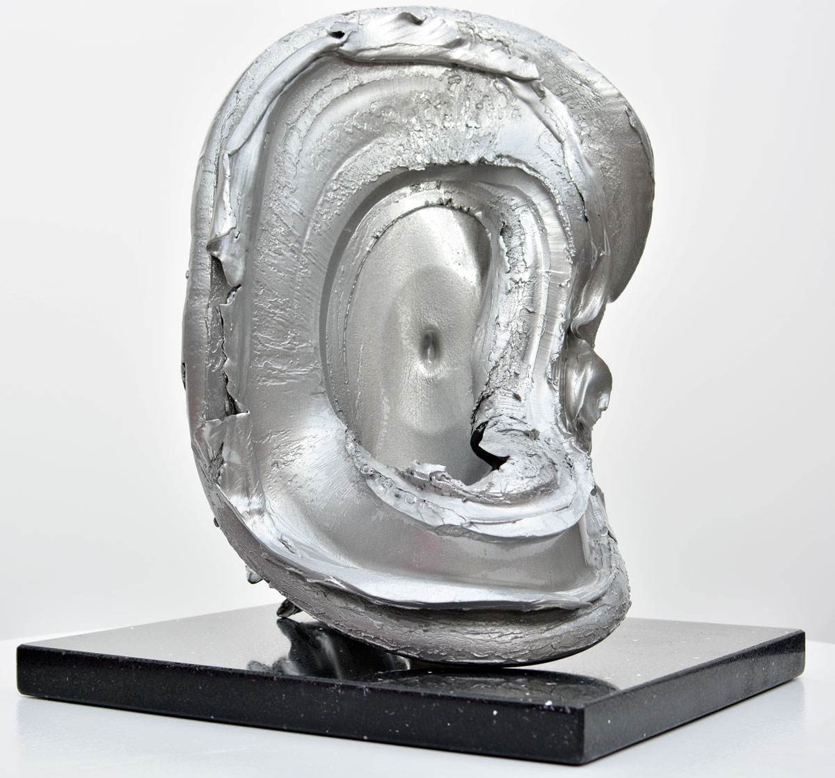 Silver sculpture on a black granite base