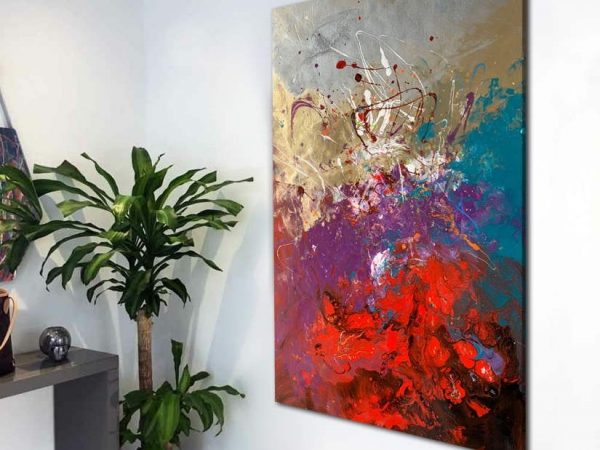 tall abstract painting in a hallway by a plant