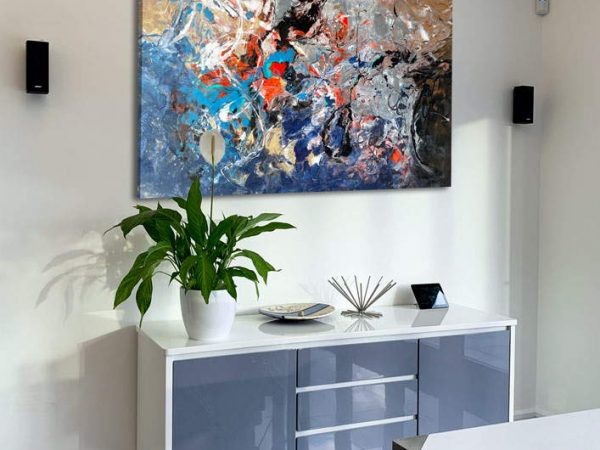 blue and gold art above a console table
