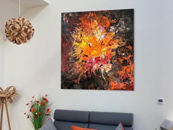 black and orange modern art above a sofa