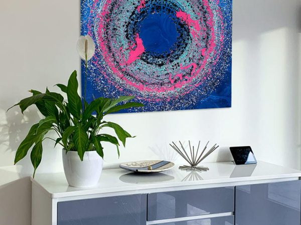 pink and blue art above a console table