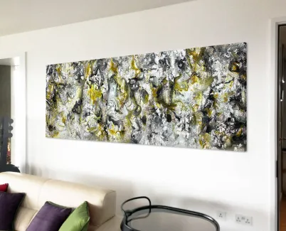 grey and yellow painting above a sofa