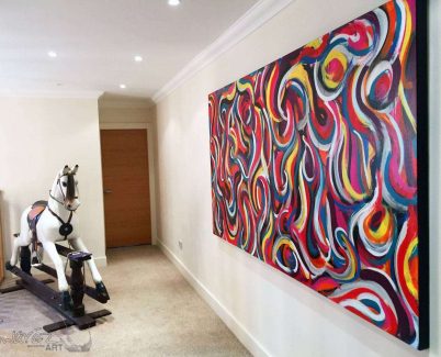 Large painting hanging by a rocking horse